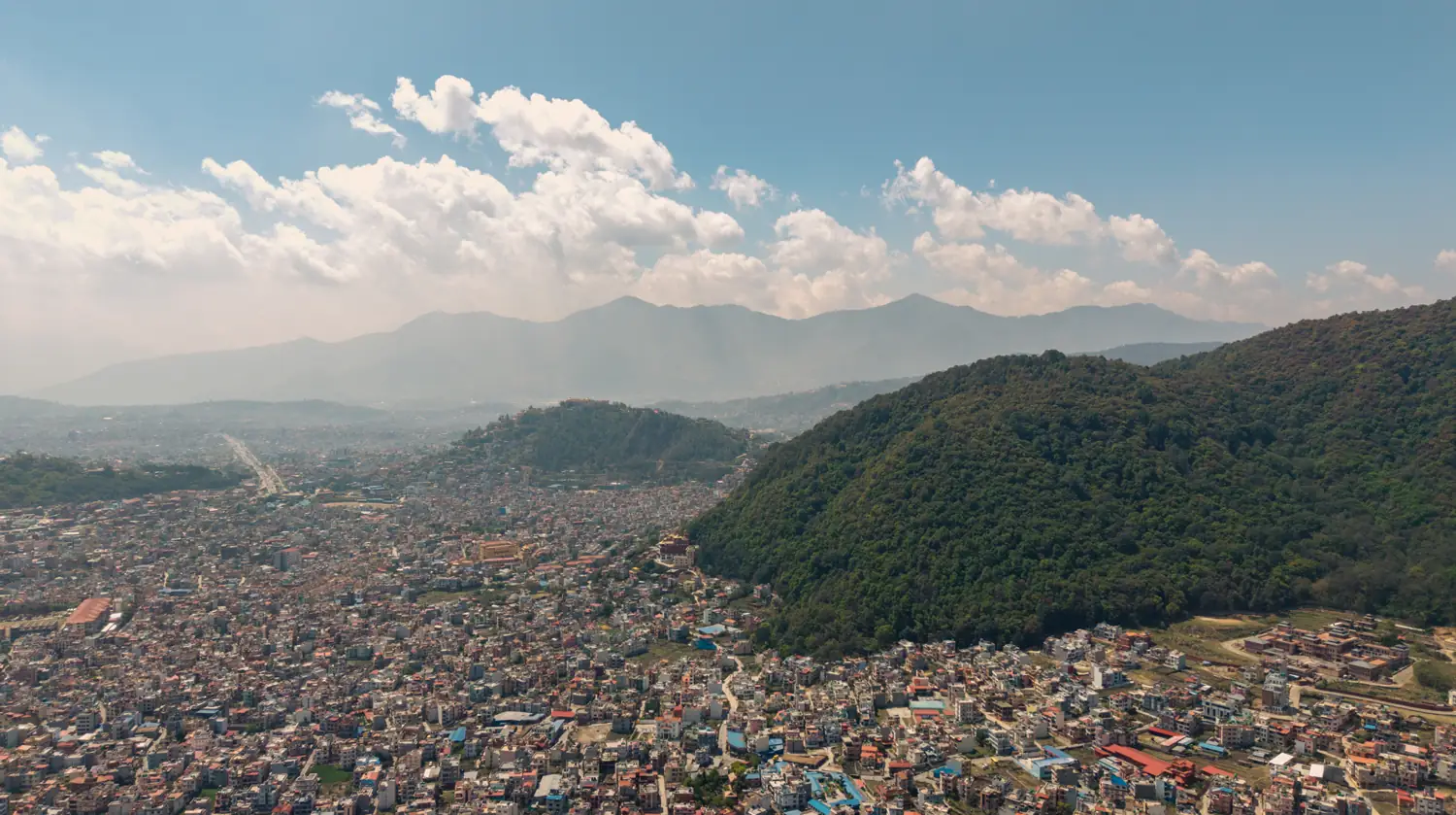 Aerial view of Kathmandu valley meeting the forested Nagarjun hills