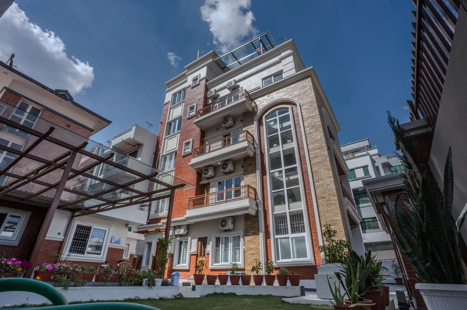 Red-brick and cream building with an arched glass stair tower
