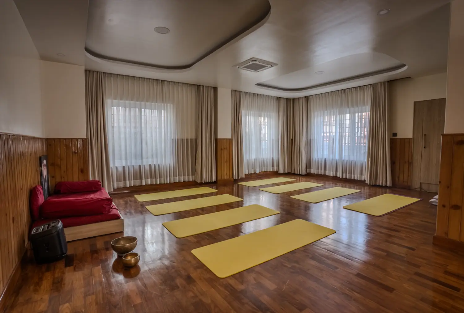 Meditation hall with mats, bolster and brass singing bowls
